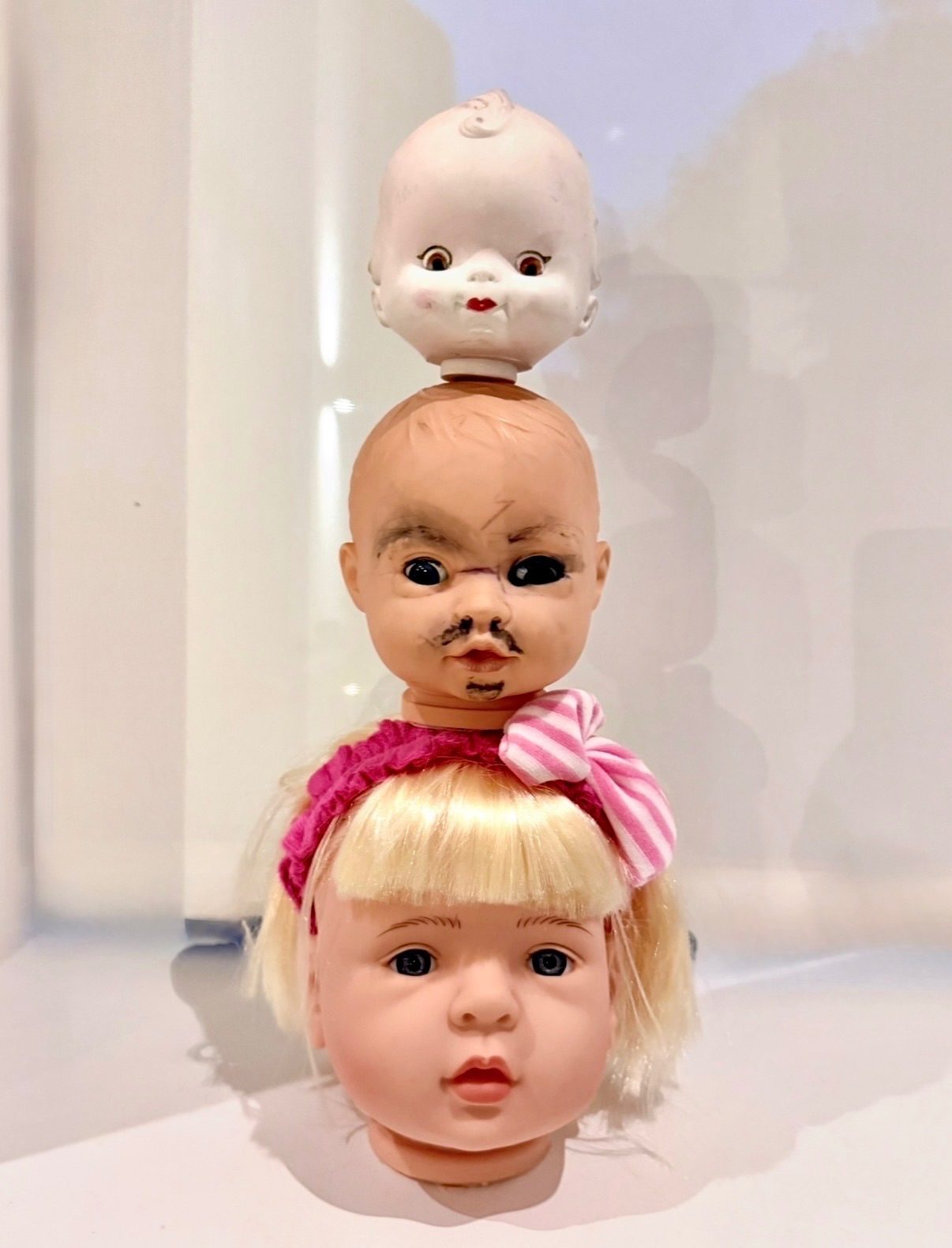 3 dolls heads piled on top of each other