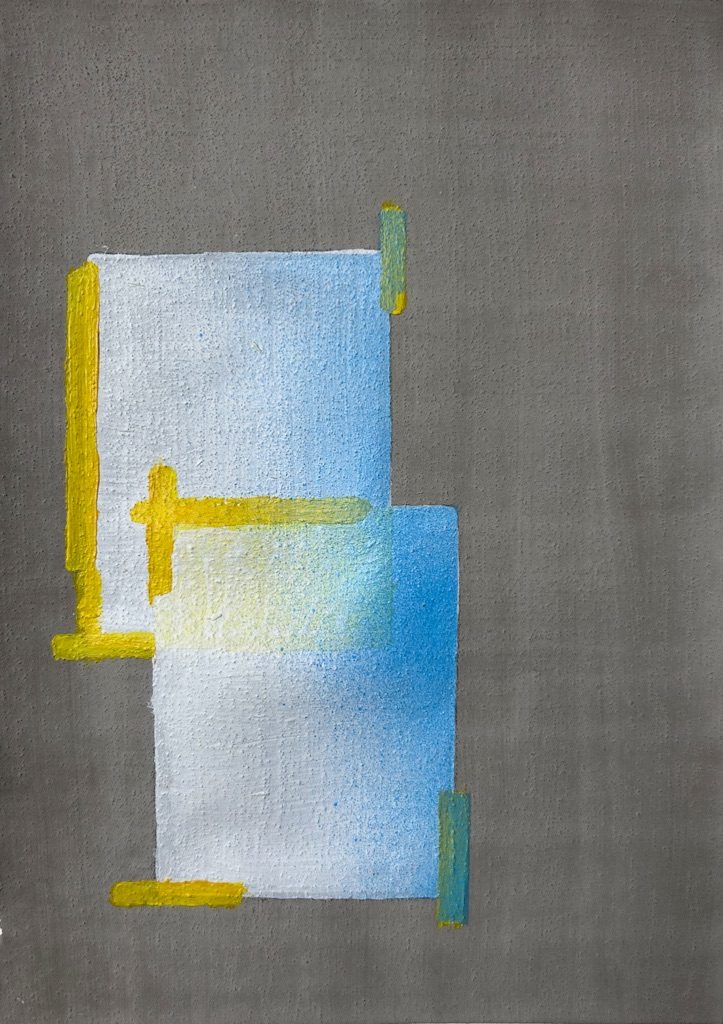 2 white blocks taped to a cement wall with some blue spray paint overspray