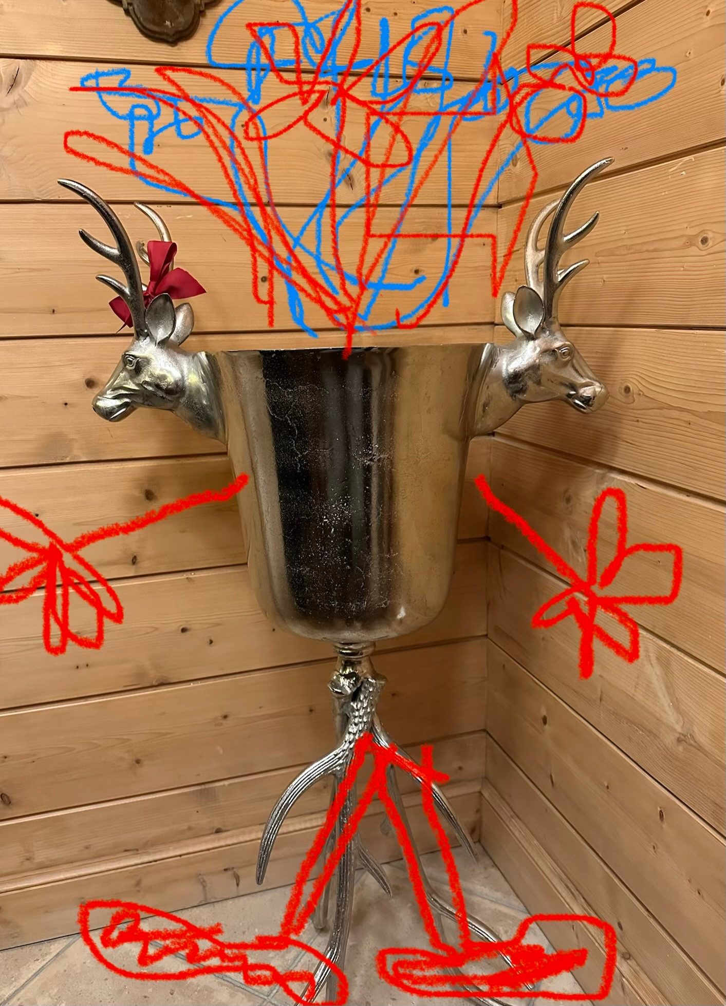 A photo of an ice bucket with two heads of stags as ornaments, drawn on by iPhone