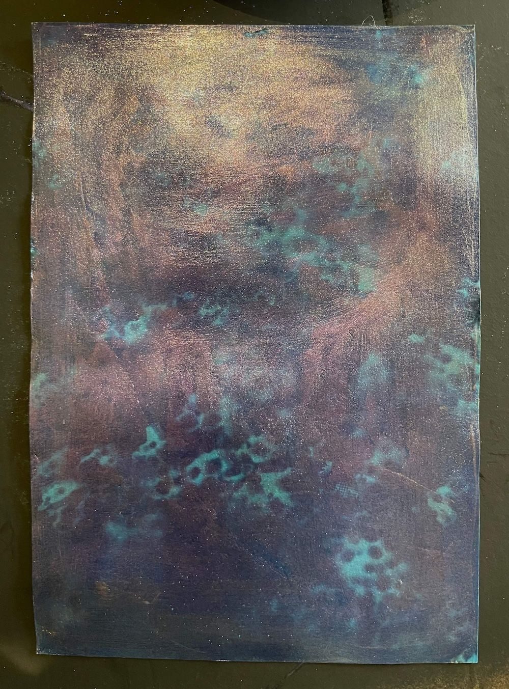 Colour shift surface over misty dark blue ground.