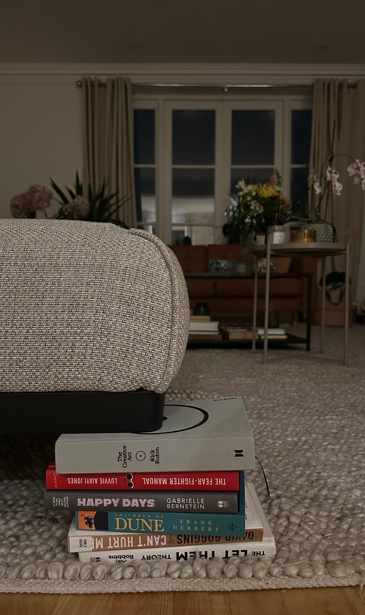 Stack of books replacing the leg of a broken sofa