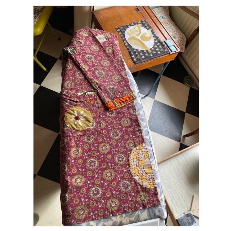 Housecoat with mending on an ironing board.