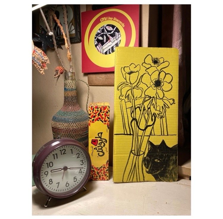 Black cat with anemones. Black ink on yellow card.