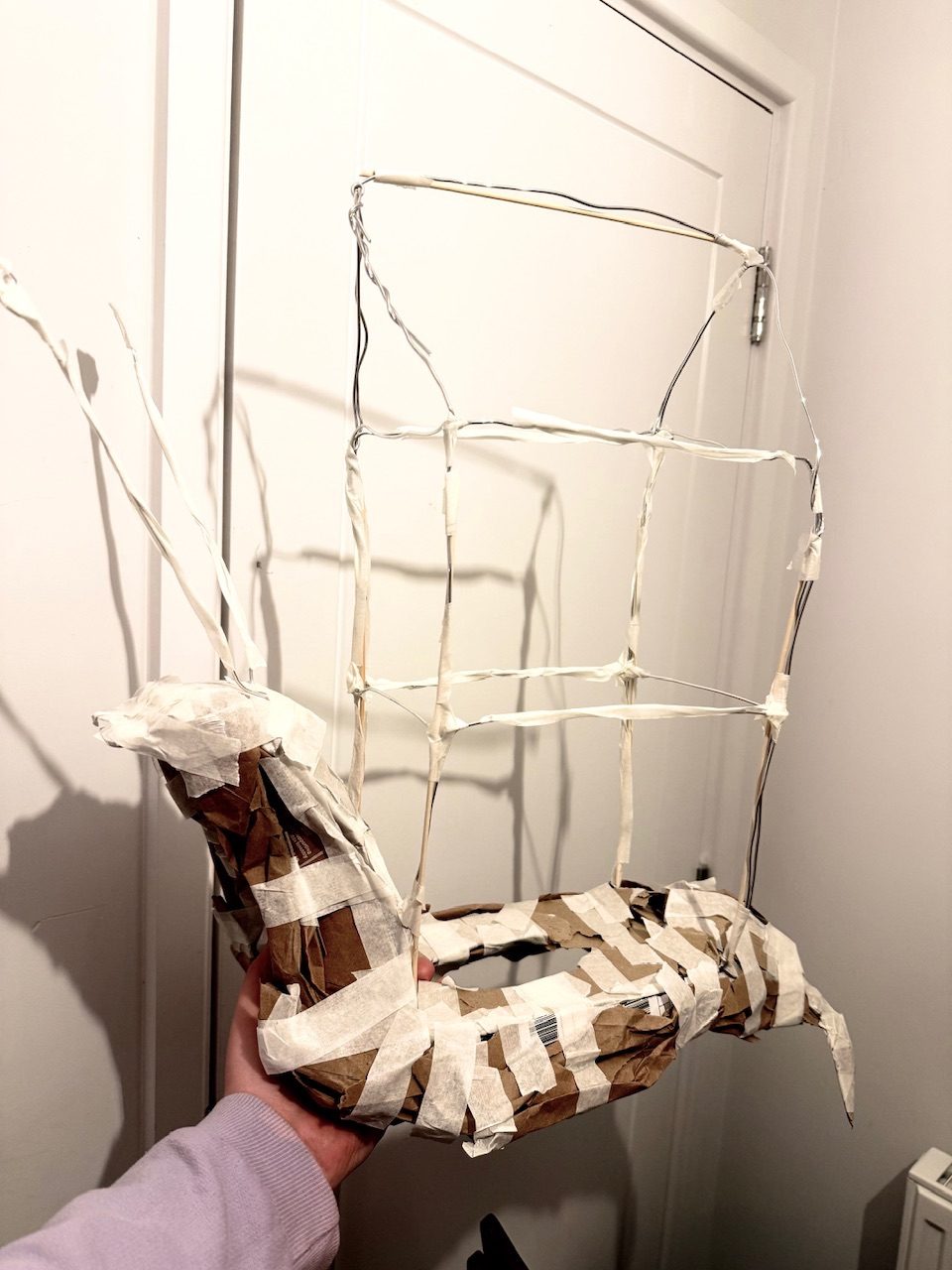 A wire and cardboard sculpture of a snail with a house for a shell