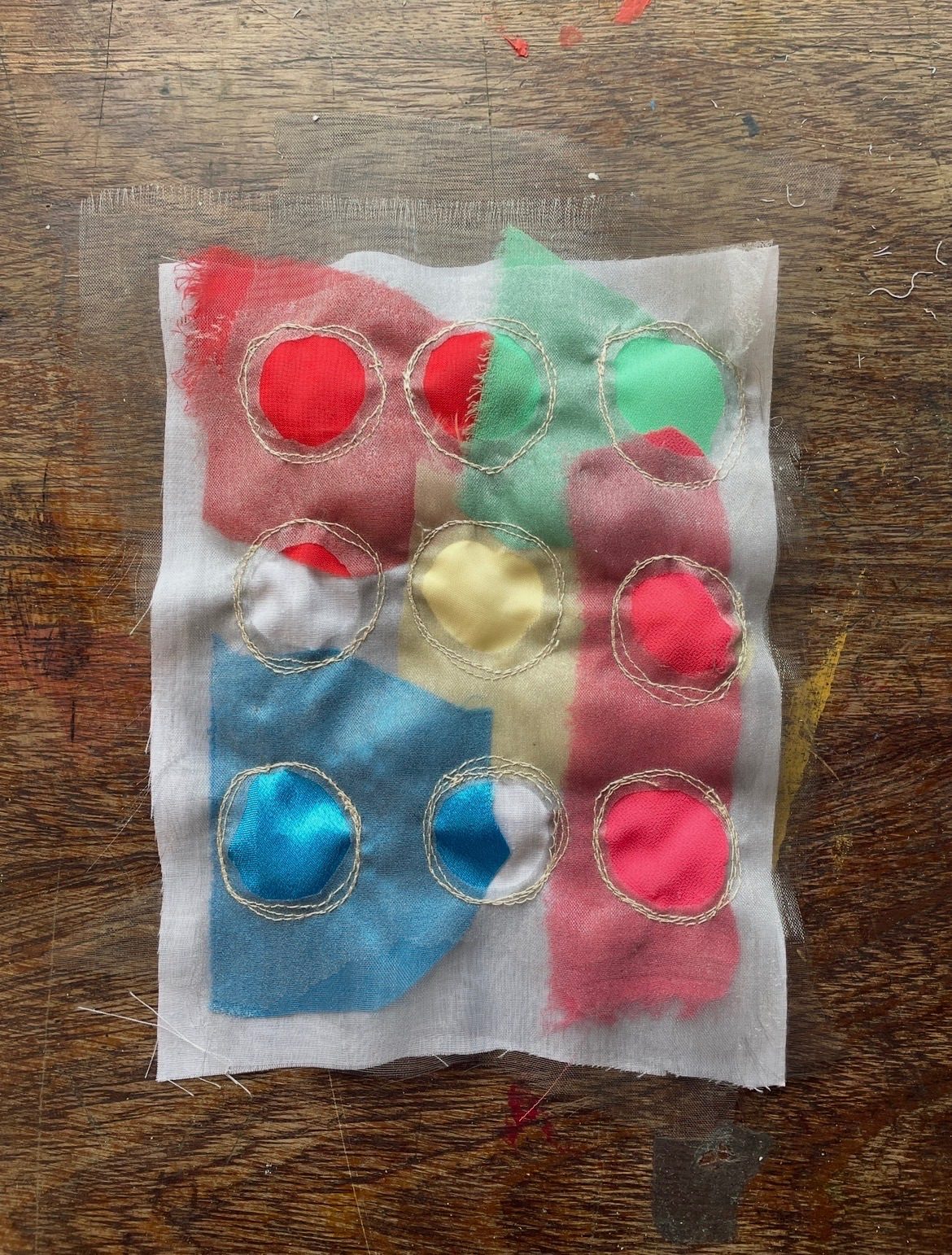 Colourful fabric sewn onto a white piece of fabric