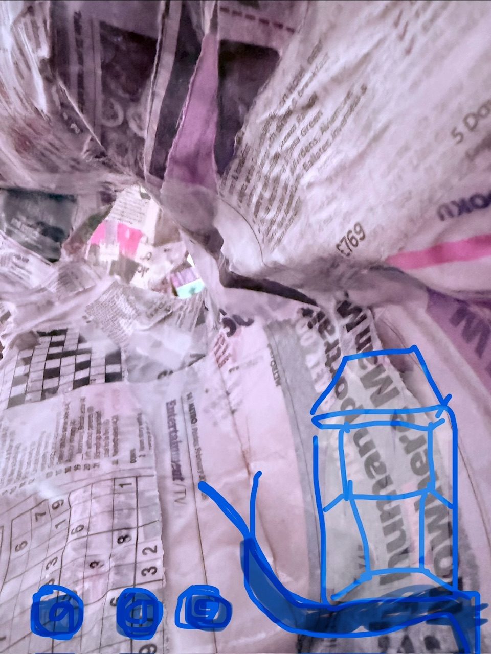 Close up of paper mache leading into a hole. The newspaper strips are still wet with glue pooling in to them. There is a scribbled digital drawing of a snail with a house for a shell and three circles making an ellipse.