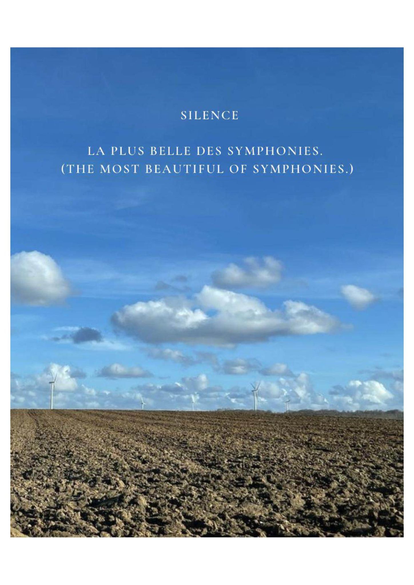 A serene landscape photograph features a vast plowed field and distant wind turbines under a bright blue sky scattered with clouds. White bilingual text overlaid on the horizon reads 