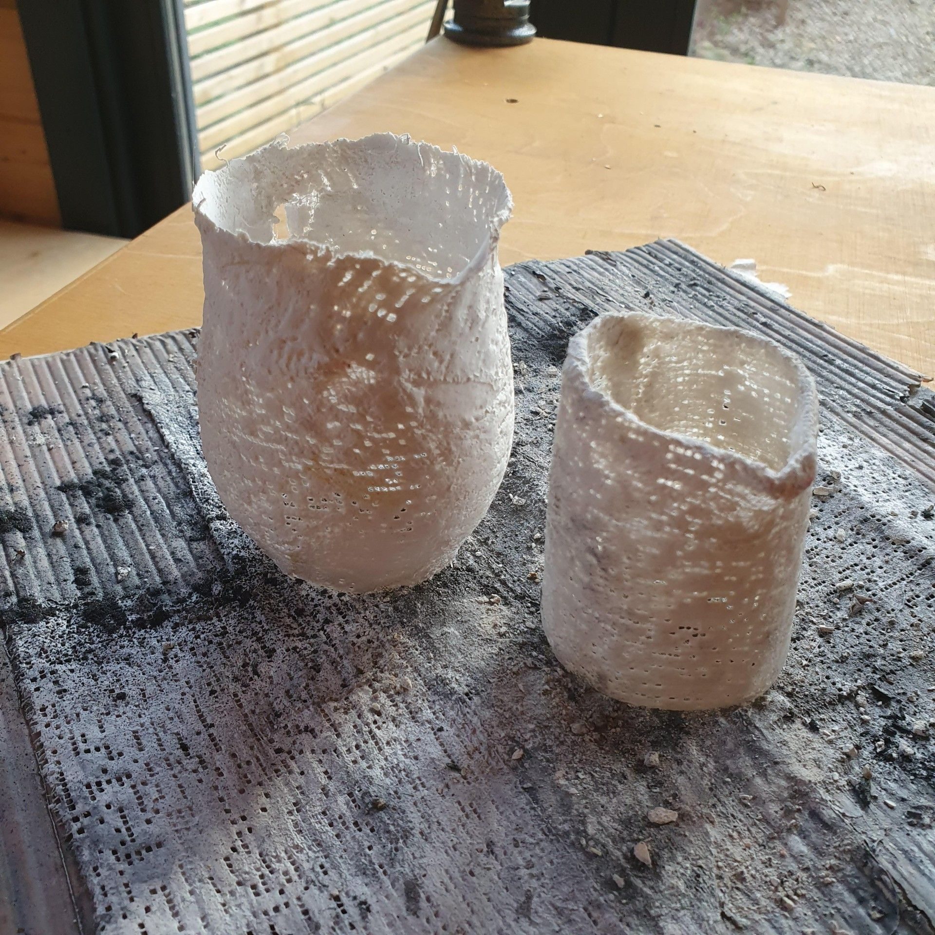 Little jars made of plaster band and now vanishing outdoors in the rain...