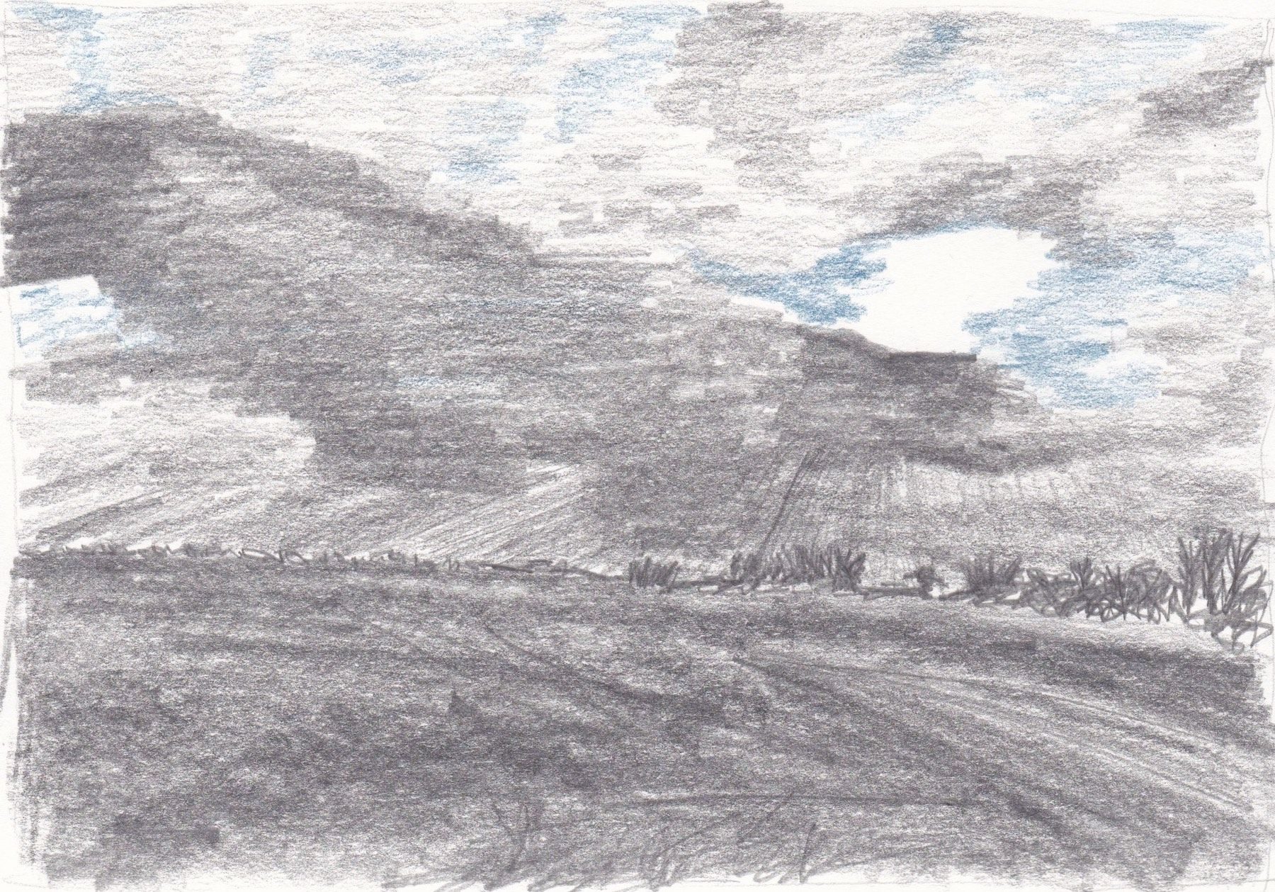 A drawing in 6B Graphite stick, hb pencil and blue coloured pencil based on a fleeting glimpse of clouds from a car in March 2016