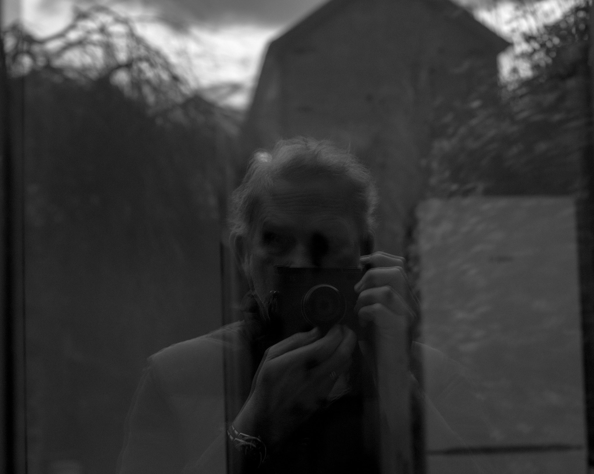 Black and White image of myself reflected in the Windows that I have just cleaned.
