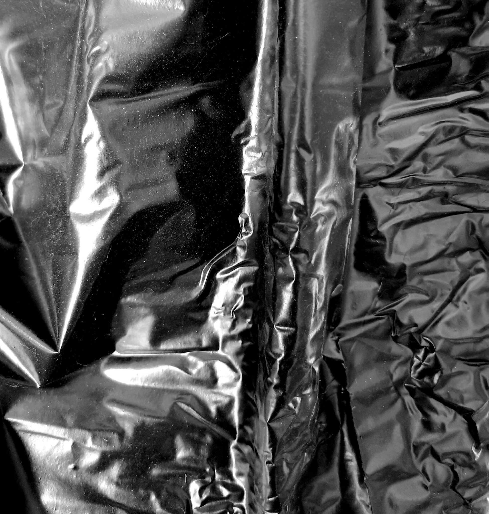 A crumped black bilinear with specks of dust scattered on it.