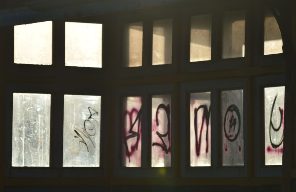 Silhouette of shelter windows. Half erased graffiti on the windows