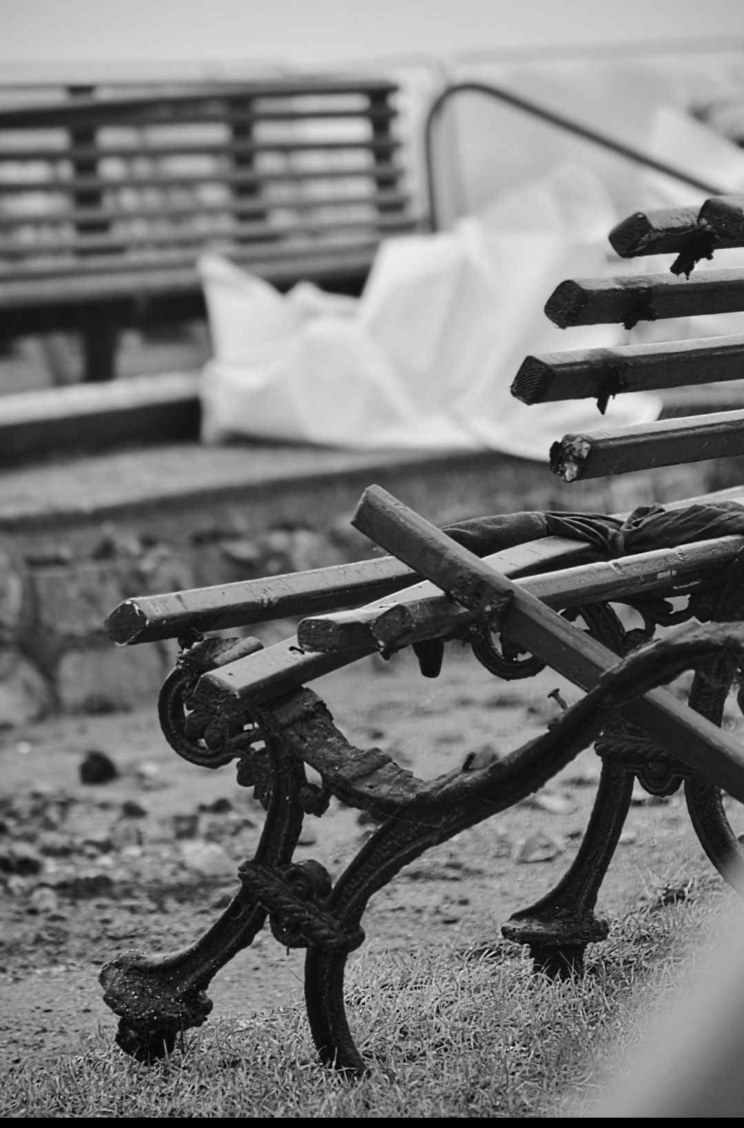 Black and white photo of the end of a broken bench