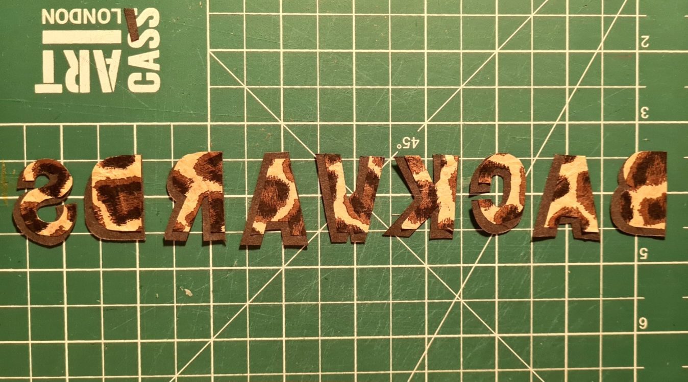 Hand cut lettering reading 'backwards' backwards