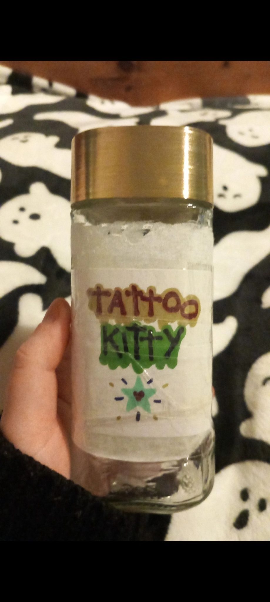 decorated old coffee jar for saving for tattoos labelled 
