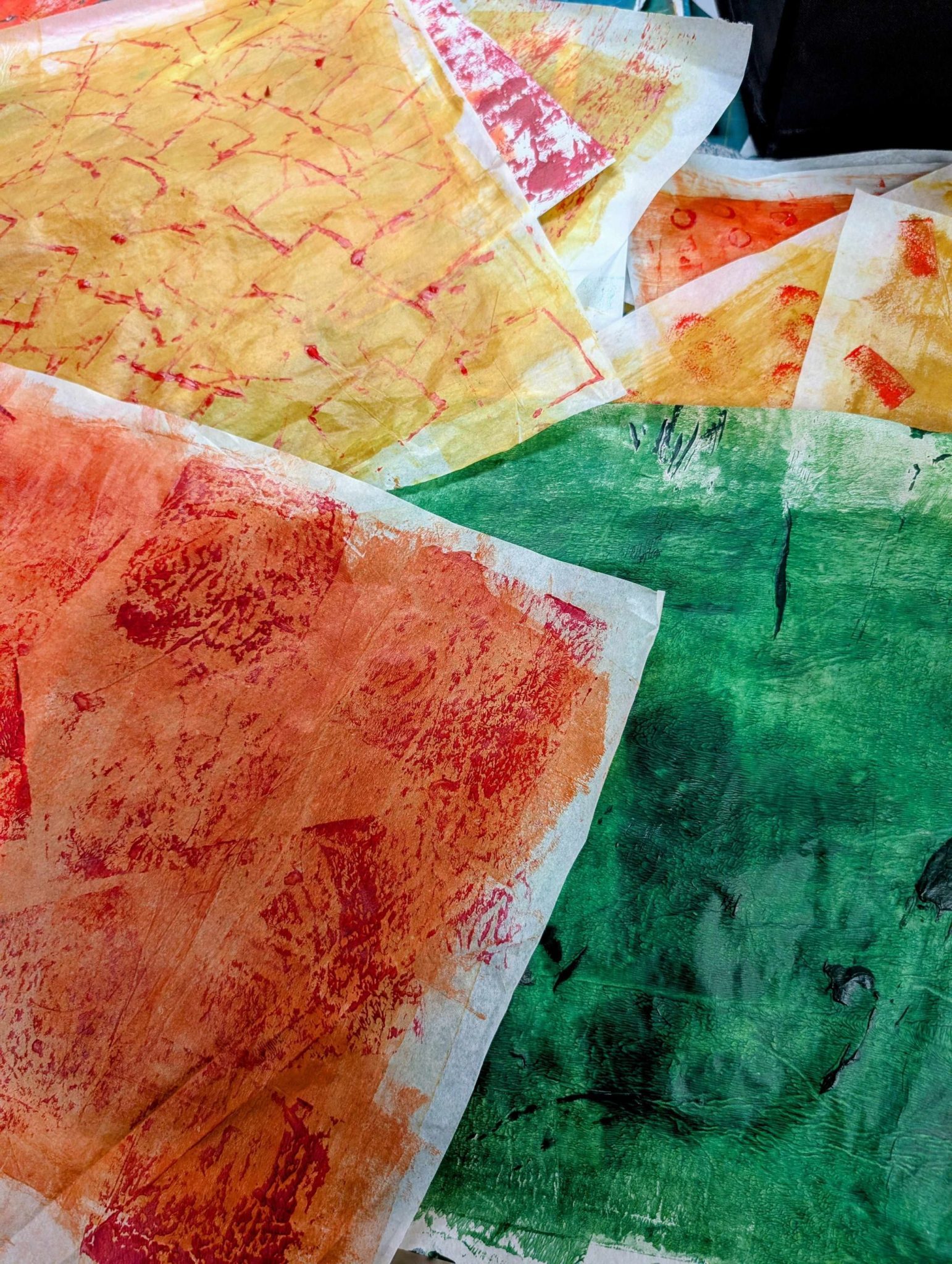 Pile of relief printed papers in yellows, orange and green