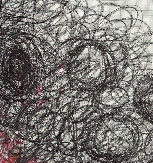 Black wax crayon spirals and a small red biro face on graph paper