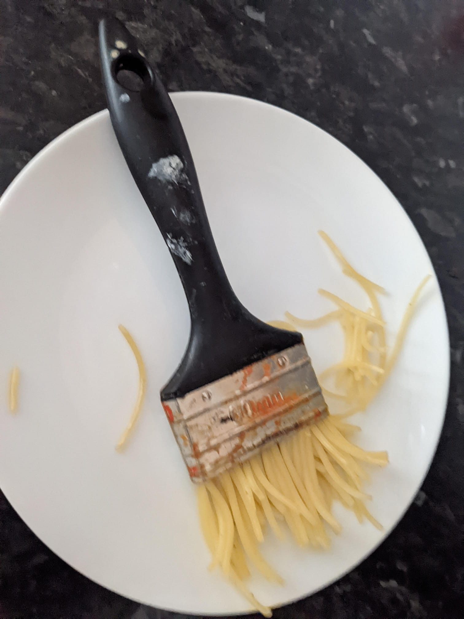 A paintbrush with spaghetti instead of bristles