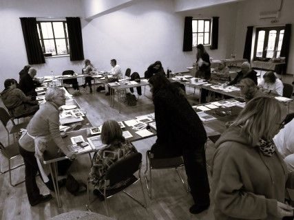 black and white photograph of a group of people in an all-day lino-printing workshop, 7th February 2026, taken from a slightly elevated position.