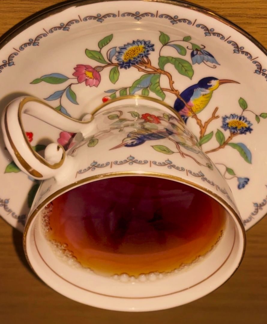 photo of a teacup with an anarchy symbol lightly reflected in the tea