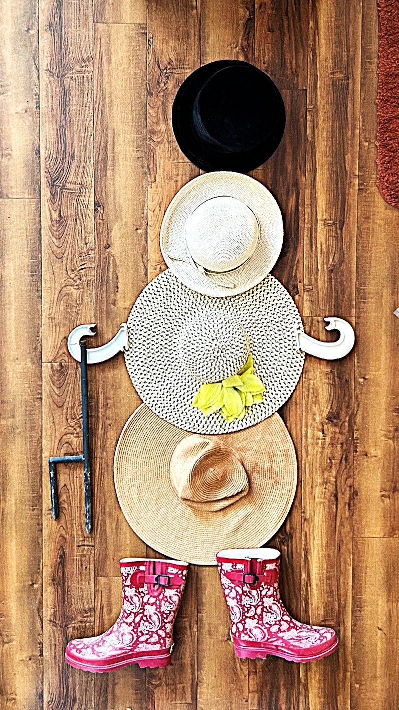 a playful snowman like figure made of hats found while cleaning the closet