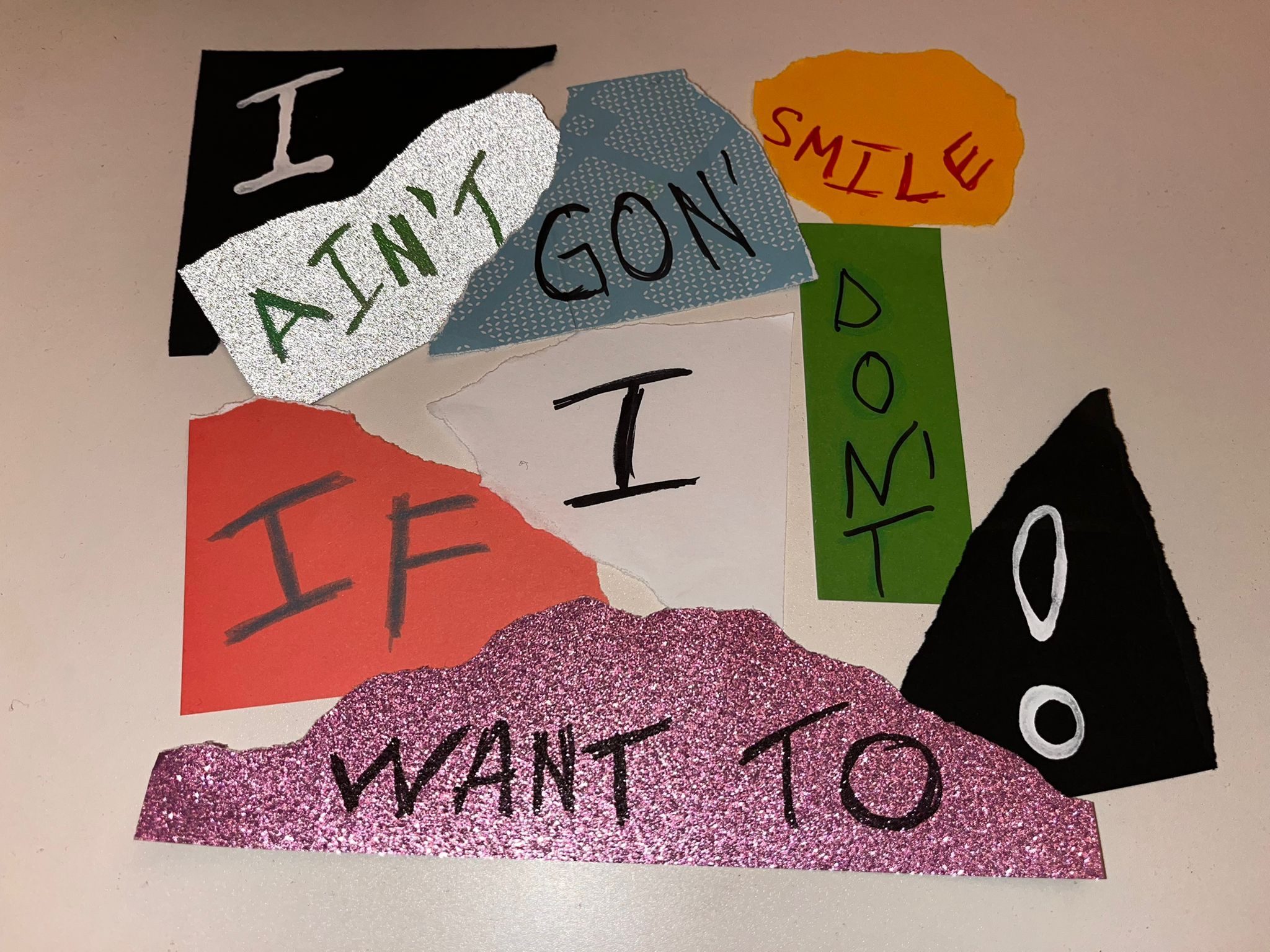 A collage of different coloured paper with a different word written on reading ‘I anin’t gonna smile if I don’t want to’