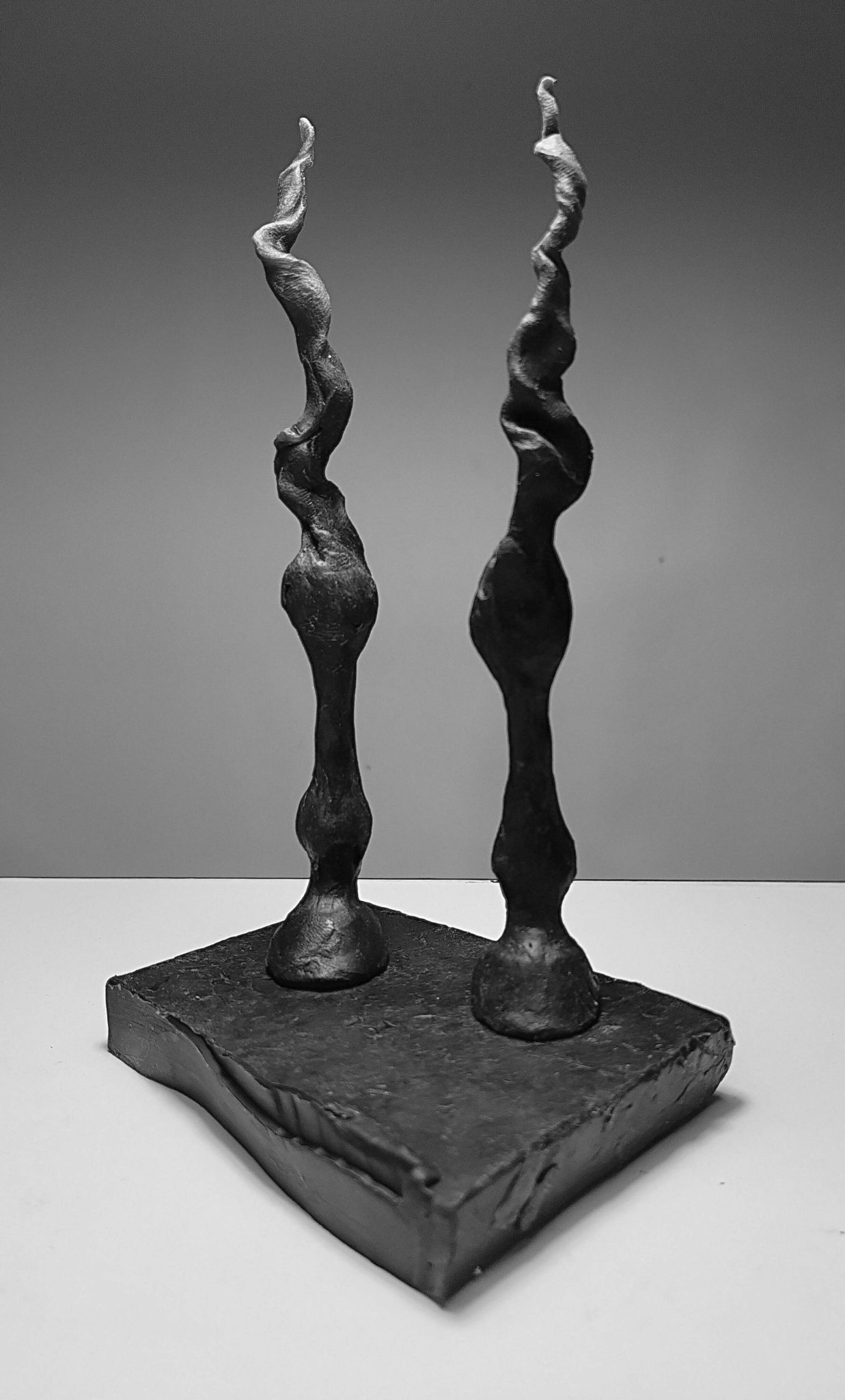 this is a small abstract sculpture of horses front legs, made in black wax