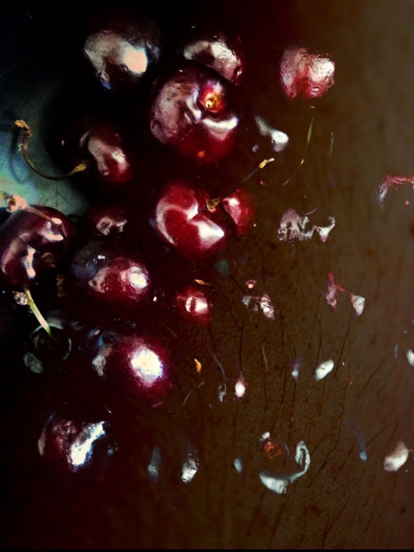 photocollage of multiple cherries over human skin with some arm hairs visible