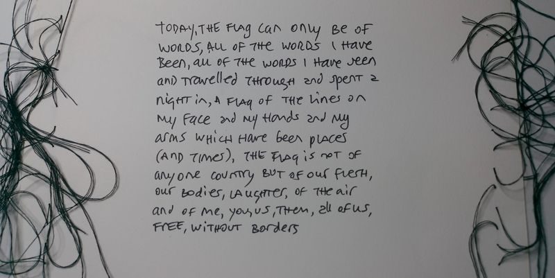 text written by hand, on a piece of paper that has black thread sewn on the left and right hand side, thread hangs loosely on the paper