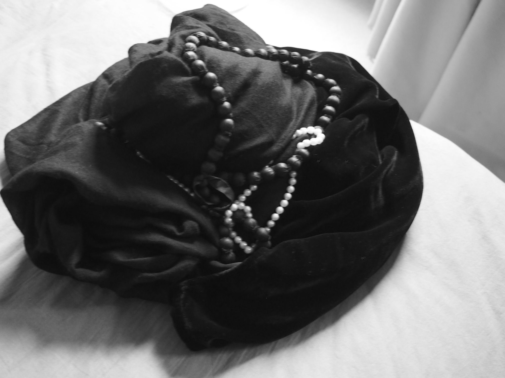 Image of diverse materials…velvet, silk, pearls, beads…embodied in an elegant entanglement of folds.