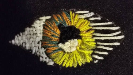 embroidered eye with different coloured thread and stiching