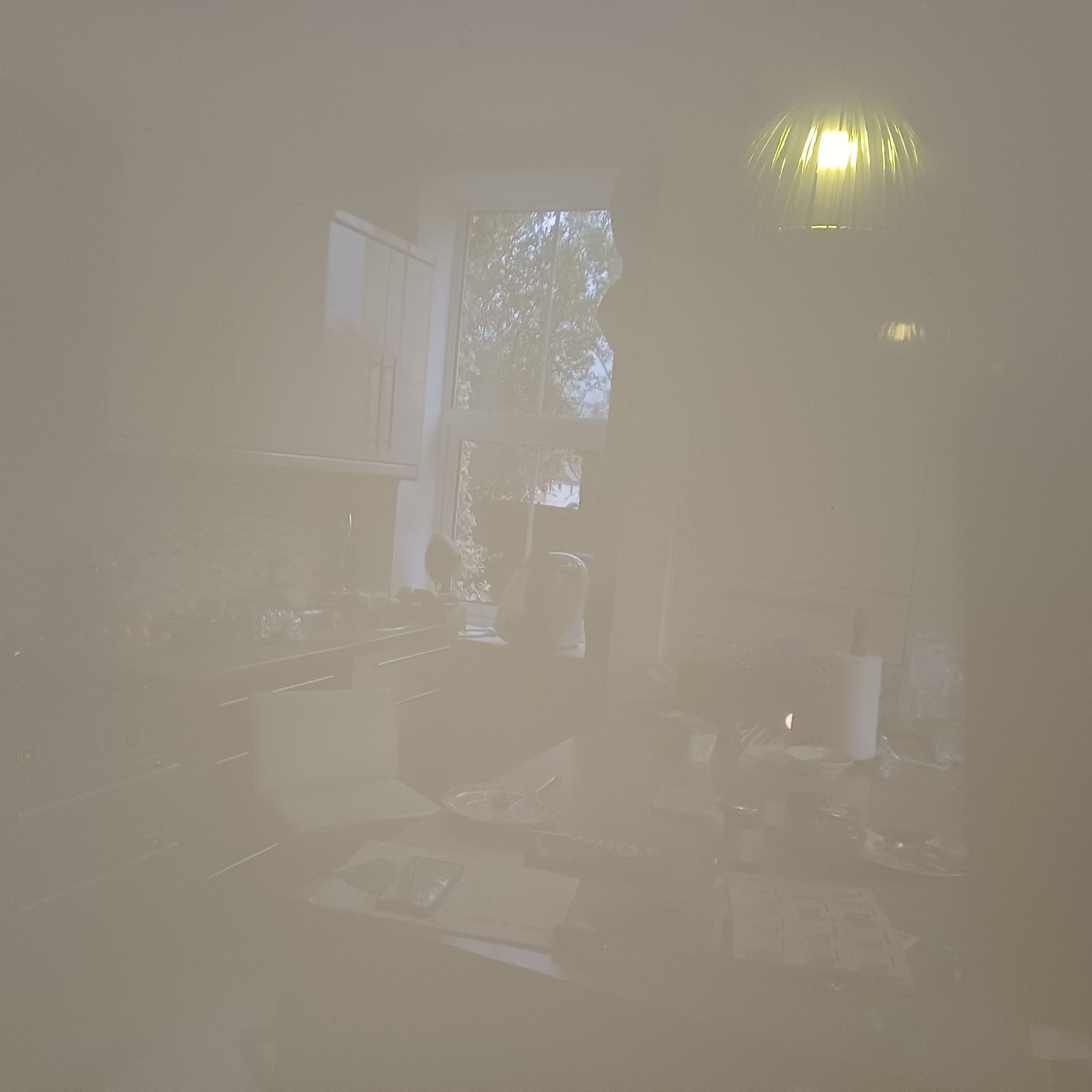 Photo of a reflection of my kitchen in one of the shiny cupboard doors looks pale and dreamy.