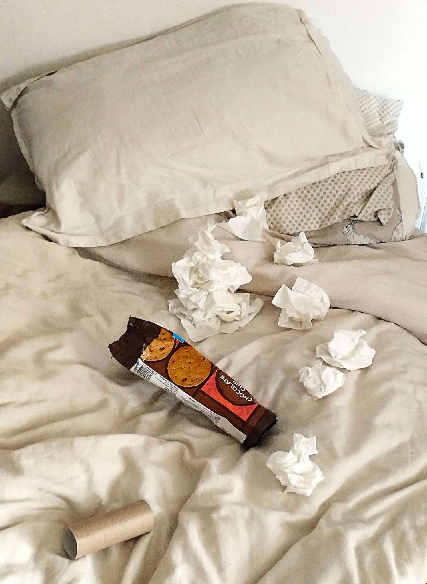 A photo of my bed covered in used tissues, chocolate chip packets and a loo roll center. I have the Flu. :(