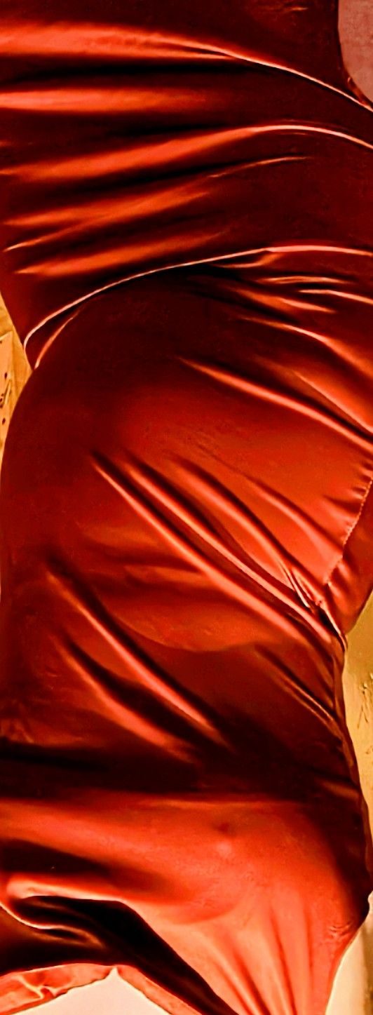 An image of a torso in an orange dress close up with creases, the body is upside down