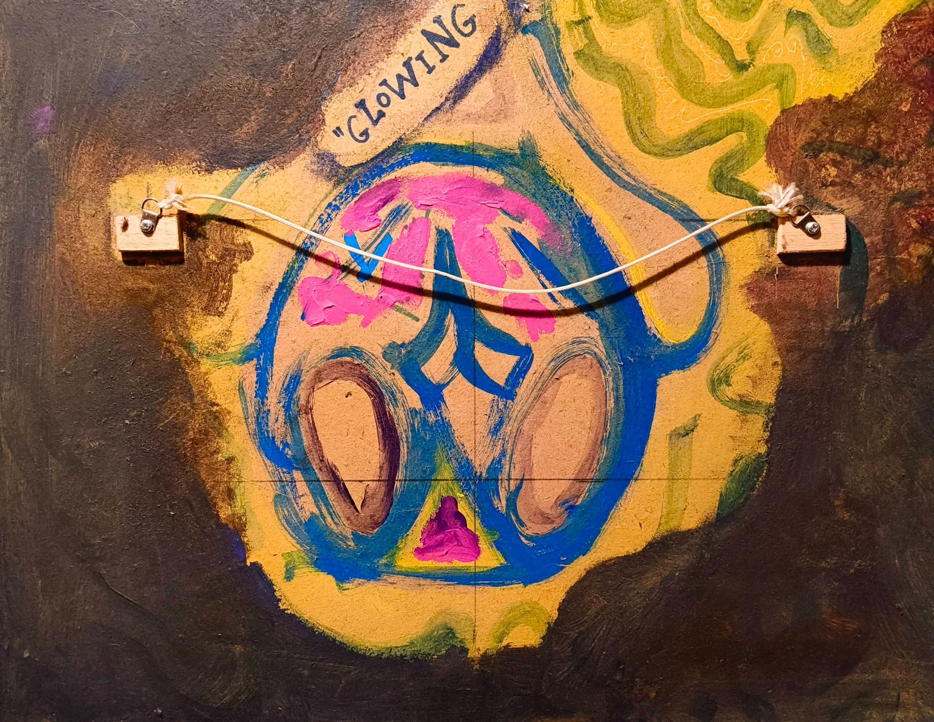 The back of a painting, with a paint doodle of an owl on it