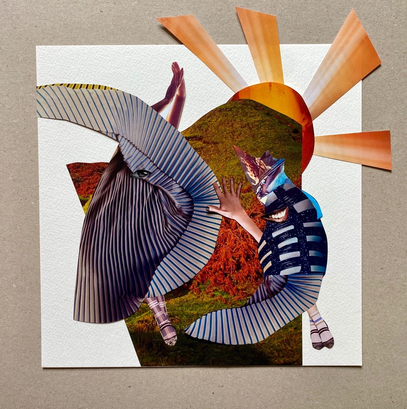 Collage on paper. rusty Scottish landscape in the background with an orange child-like sun with rays. Two amporphous swishes of fabric alluding to dancers, in the foreground,  they are almost human, they both have swing crossed legs, one has one eye and two arms outstretched, one has a mouth and one arm.