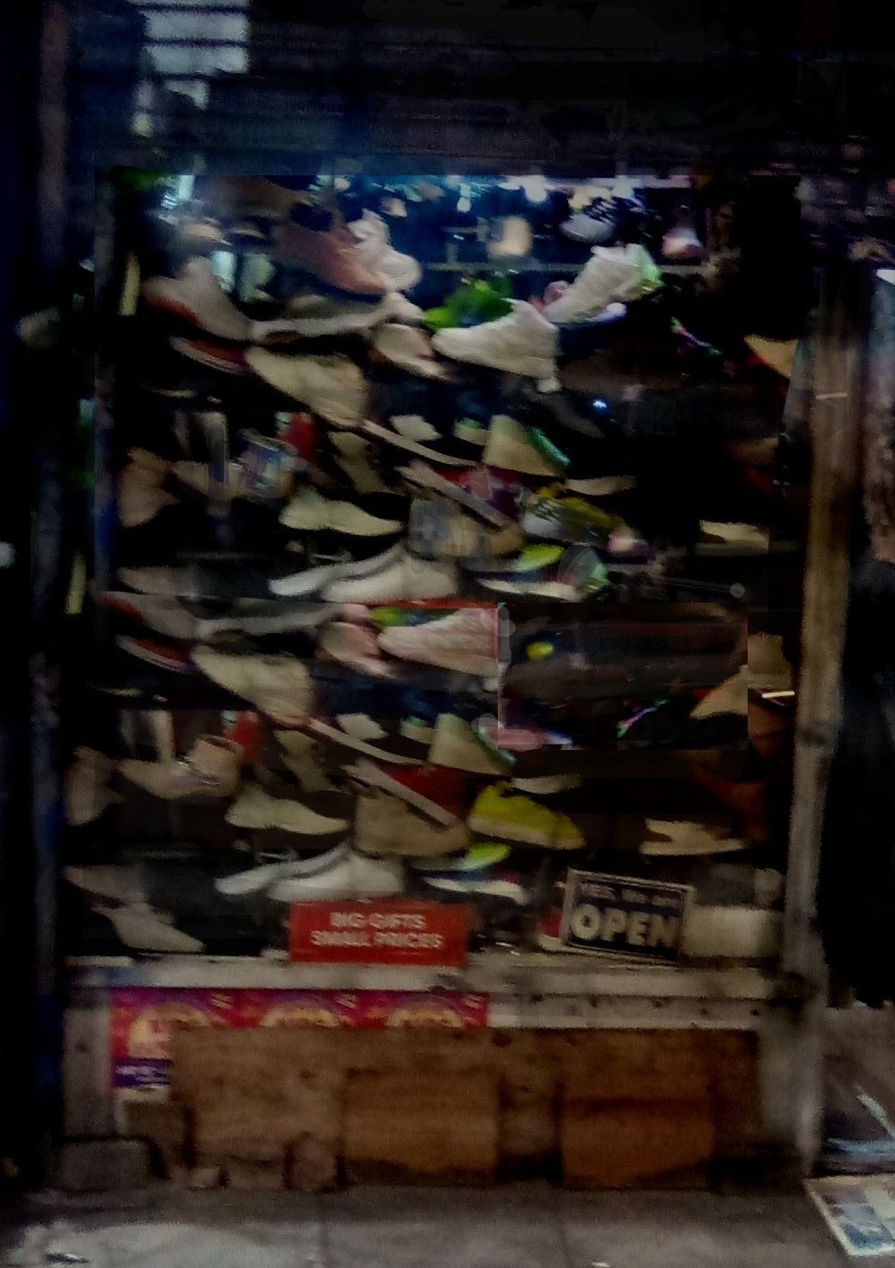 street photo with digital enhancement. shoeshop window full of piles of shoes.