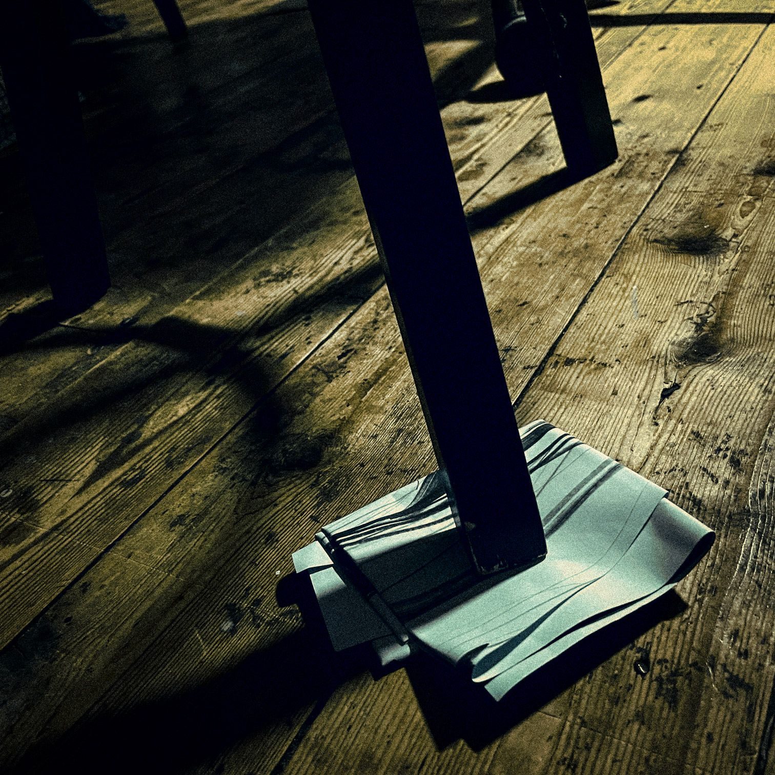 A folded piece of paper underneath a table leg