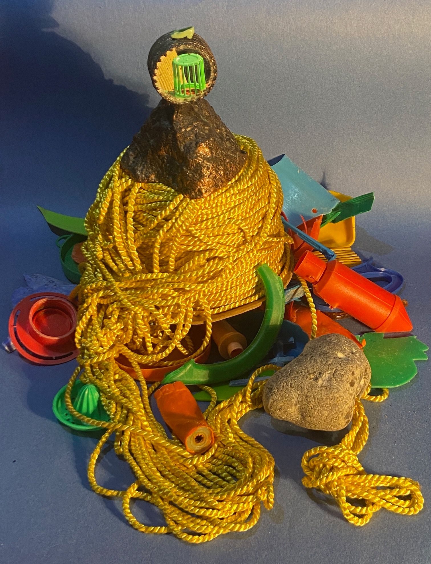 the golden chord mountain with it's coppper top now has a mirror for a face with the tiny show sitting on top; a jangle of coloured plastic has giving the mountain a raft