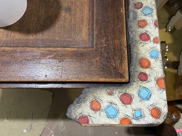 an opened old bureau, just a corner can be seen, but there's piece of semi burnt 1950's or 60's lino attached to it