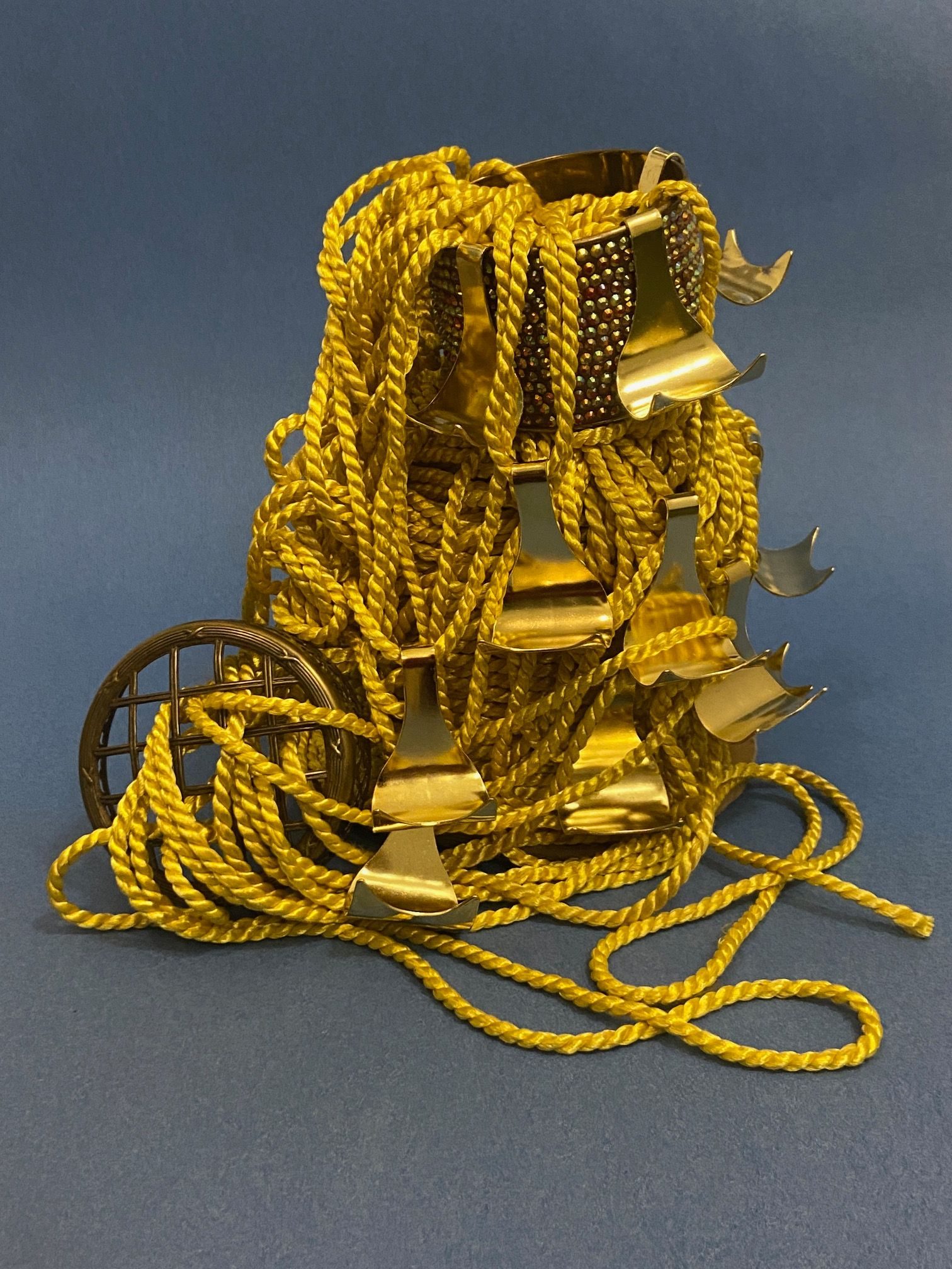 a mountain made of golden cord, with some old metal structures and ten gold hooks