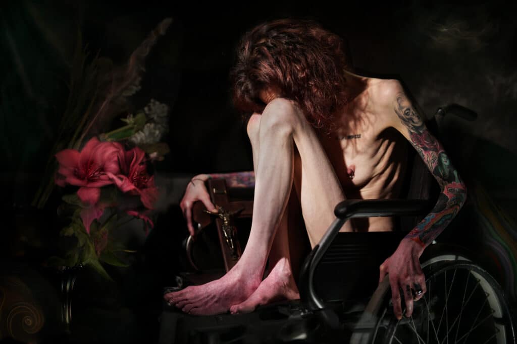 Portrait of a person sat naked in a wheel chair