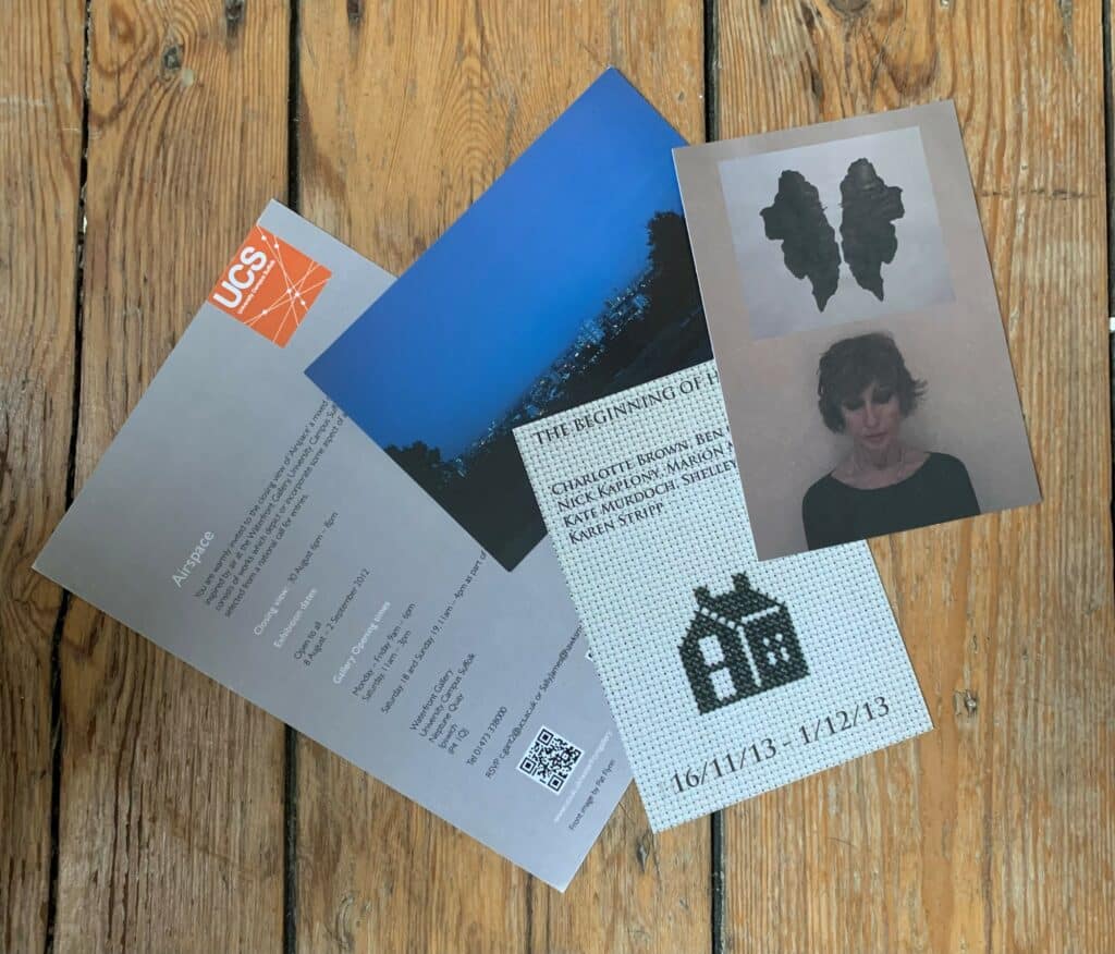 A spread of printed invitations on a wooden floor
